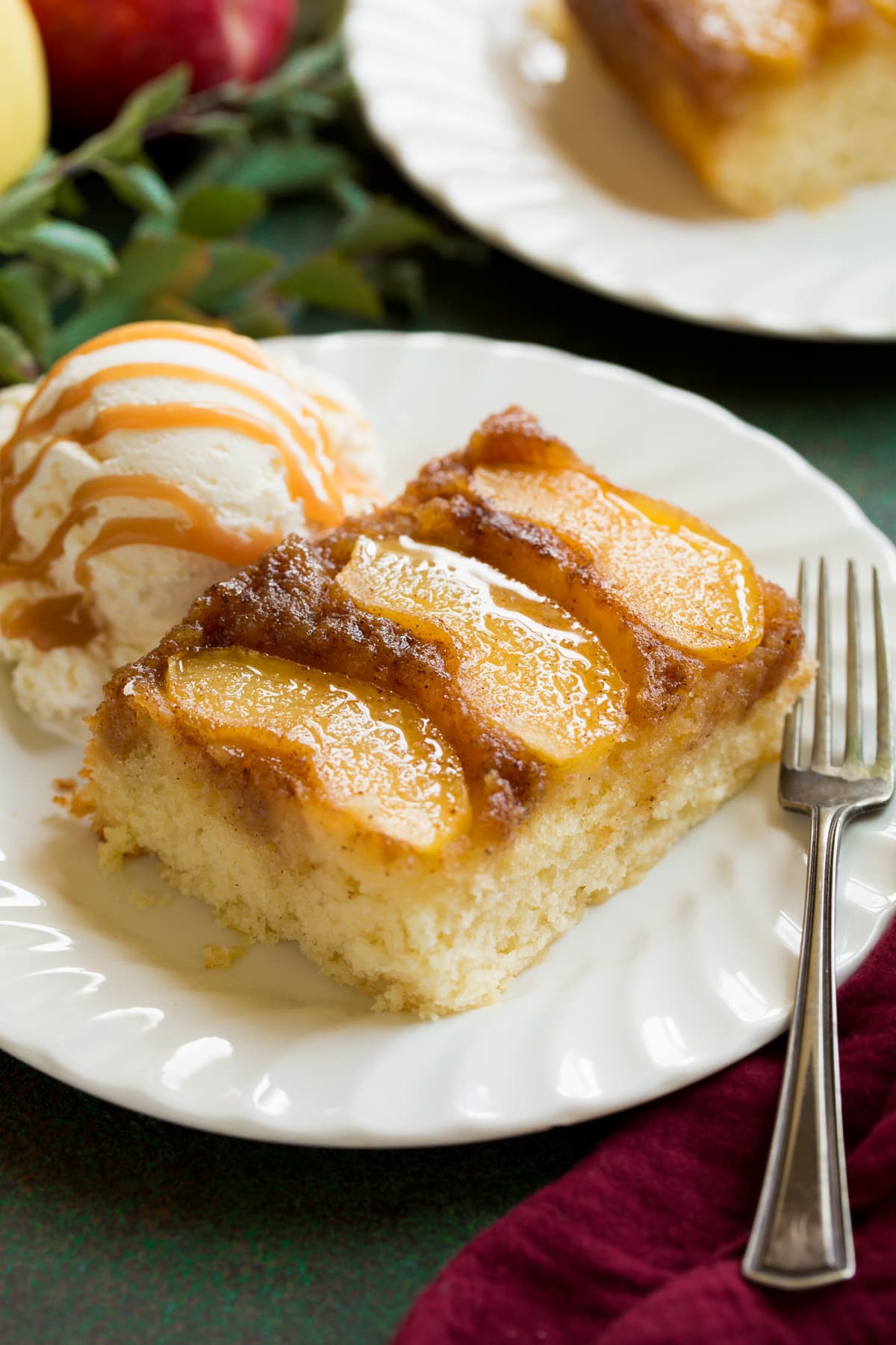 Slice of apple upside down cake on a white dessert plate.