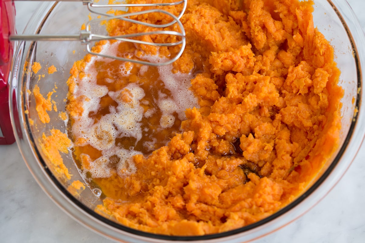 Mashed Sweet Potatoes - one of the best fall side dishes! These really are the best mashed sweet potatoes the secret ingredient is the browned butter! #mashedpotatoes #sweetpotatoes #sidedish #thanksigving Adding browned butter and maple syrup to sweet potato mixture.