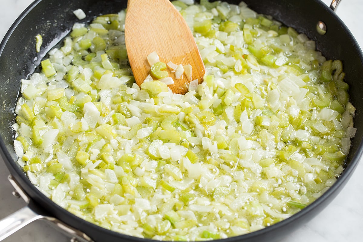 Sautéing celery, onions and garlic in a skillet with butter.