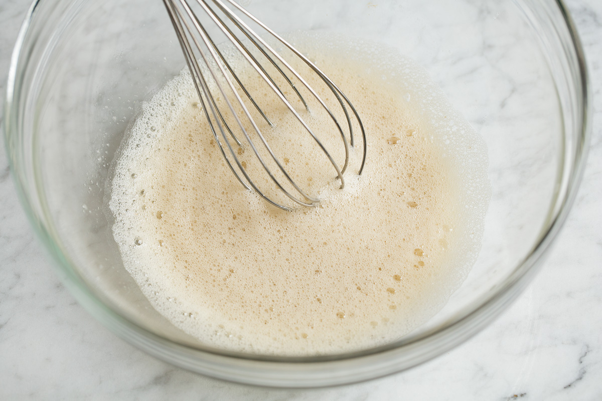 Frothy egg white mixture in glass bowl.