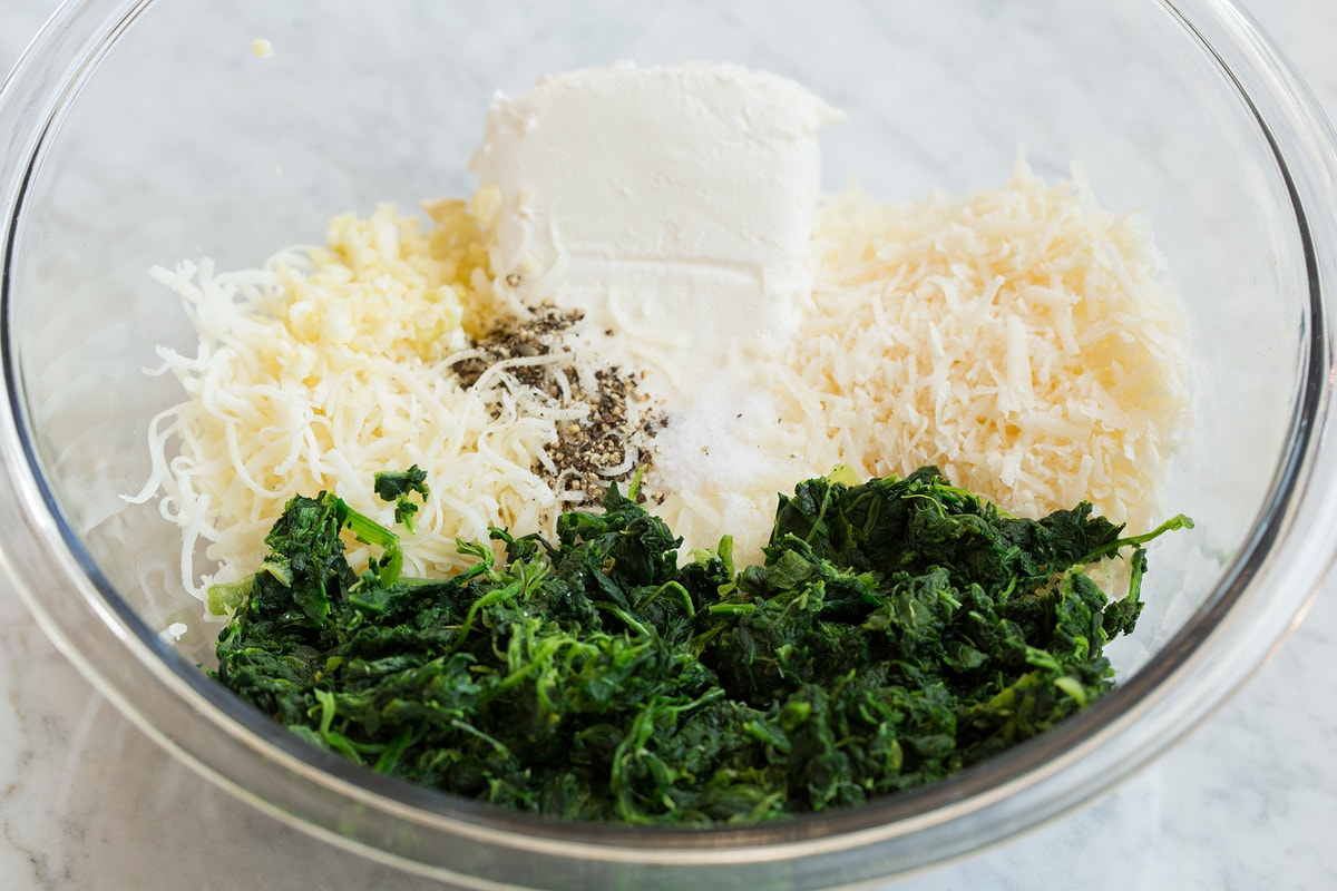Stuffed Mushrooms Second step of making stuffed mushrooms shown here, mixing the cheeses and spinach in a mixing bowl.