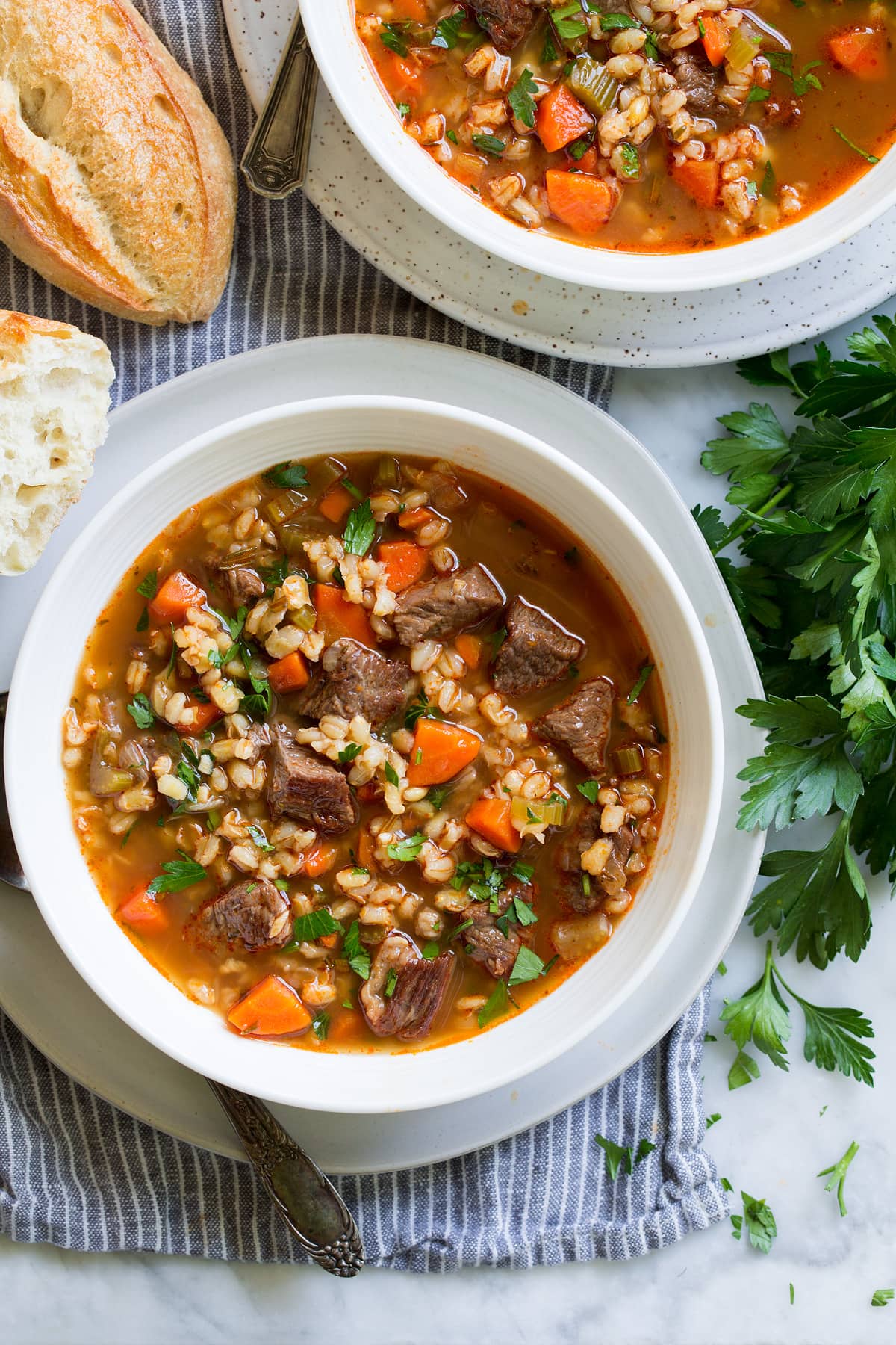 Overhead image of beef and barley soup in a serving bowl.