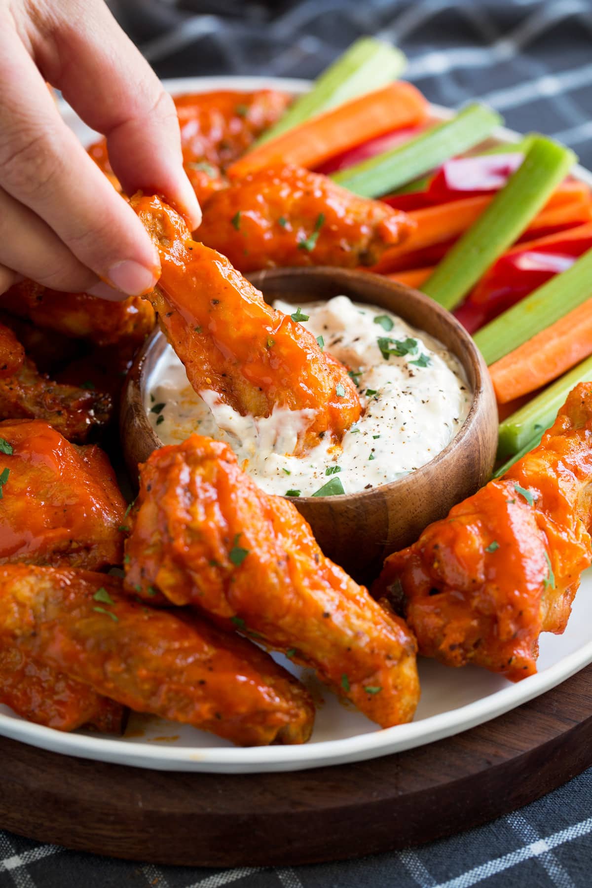 Buffalo wings dipped in blue cheese dip.