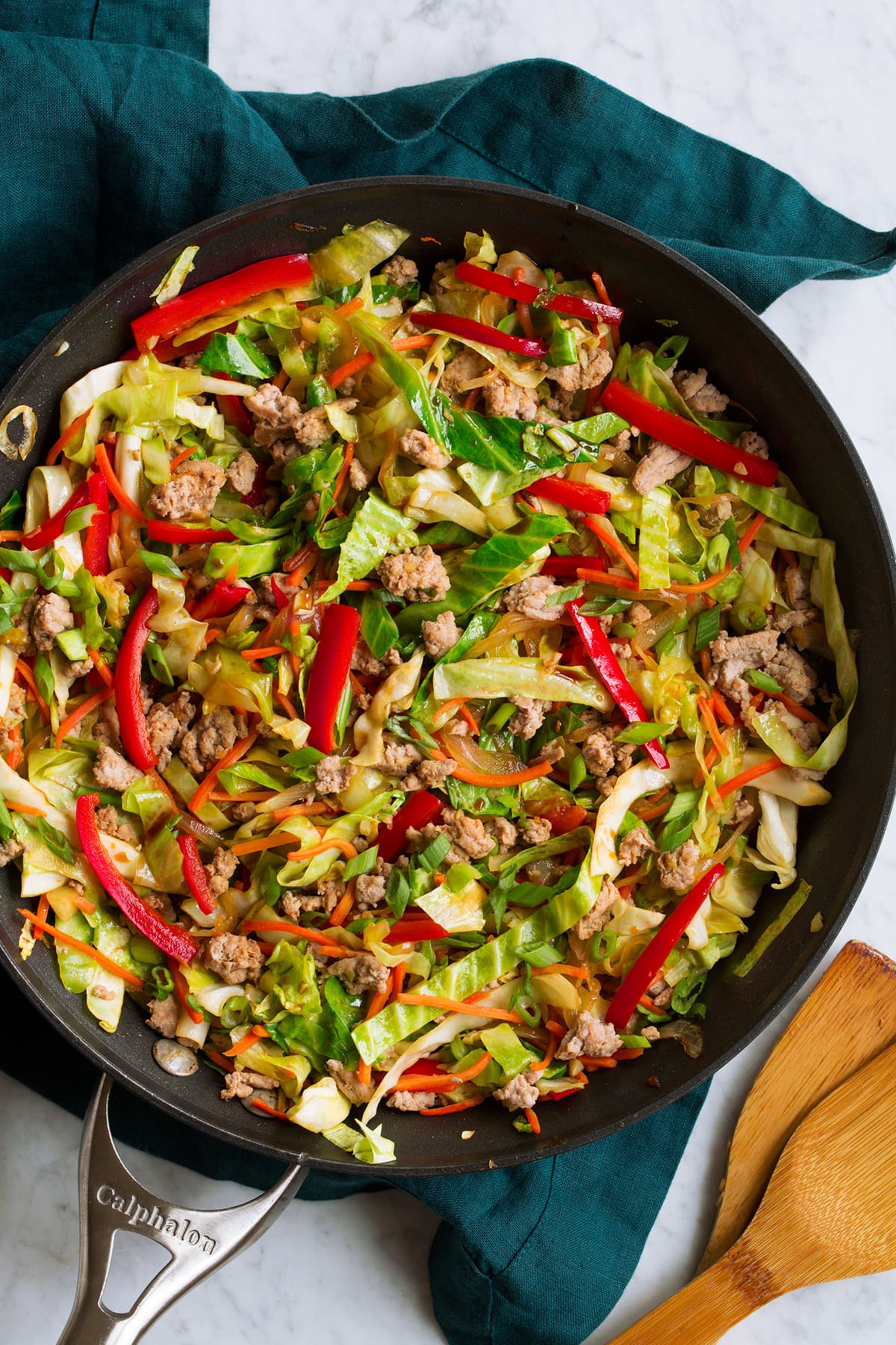 Overhead image of egg roll in a bowl in a skillet shown after completed cooking. In it you see cabbage, ground turkey, red bell pepper, and carrots. 