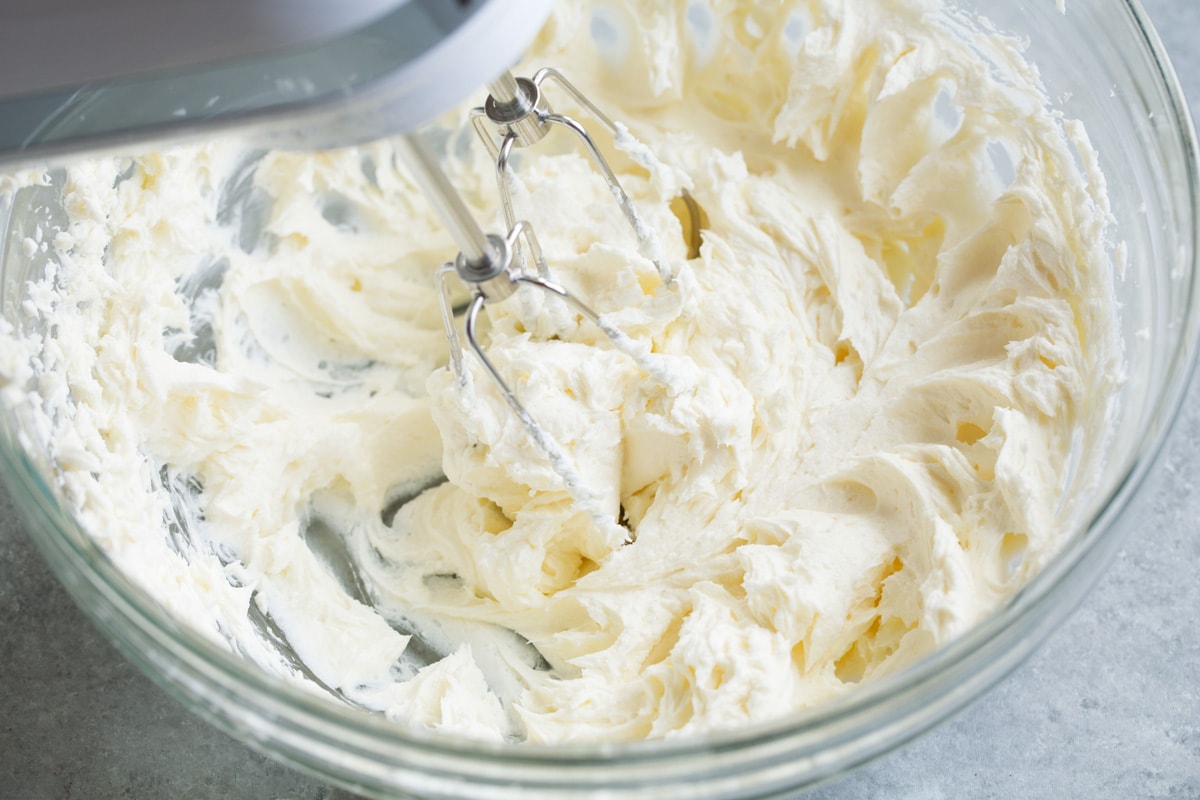 Cream cheese and butter shown after blending with beaters resting in mixture.