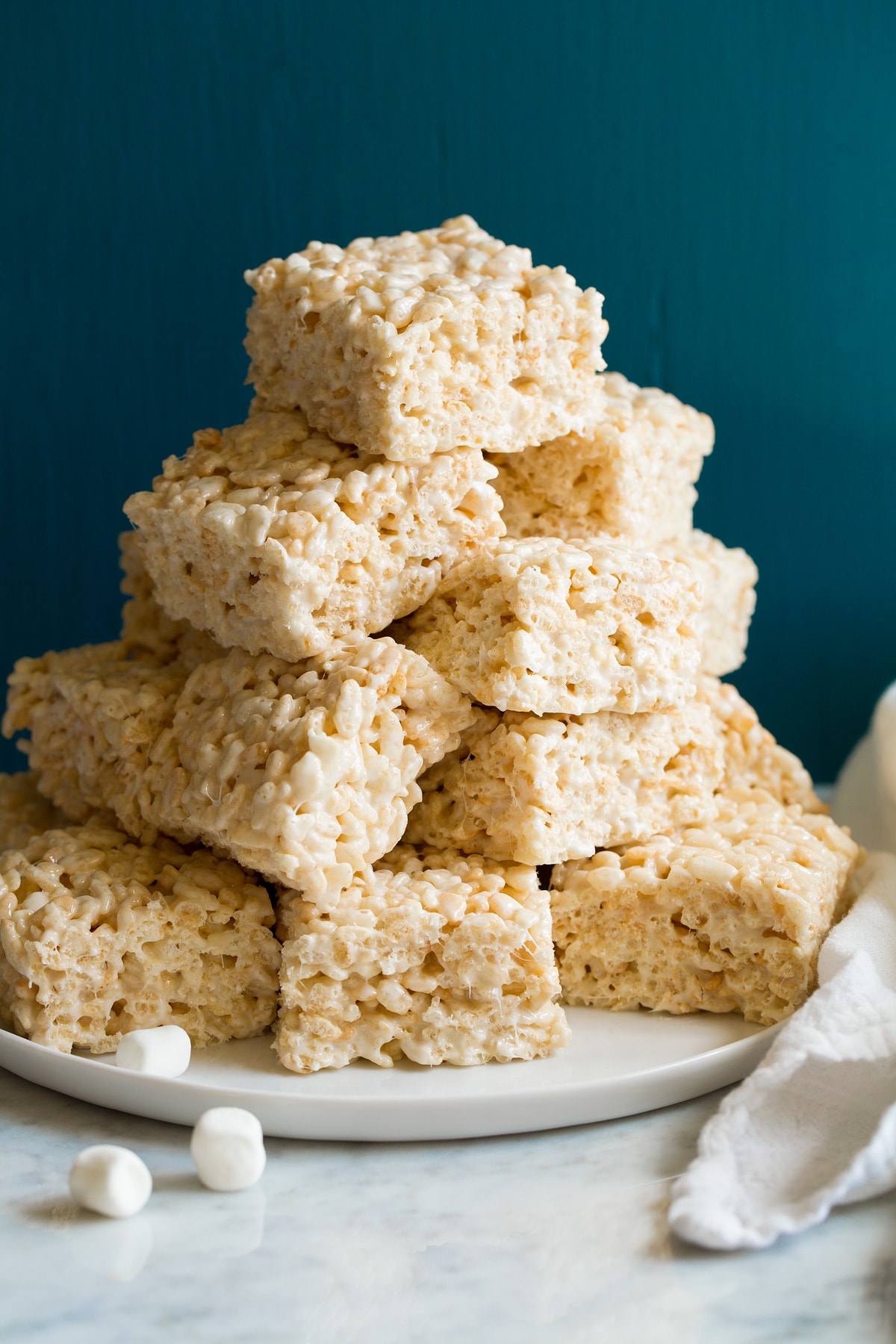 Stack of cut rice krispie treats on a platter.