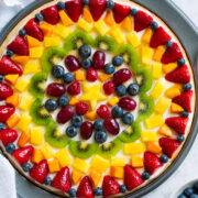 Homemade fruit pizza decorated in a artistic pattern with colorful fresh fruit.