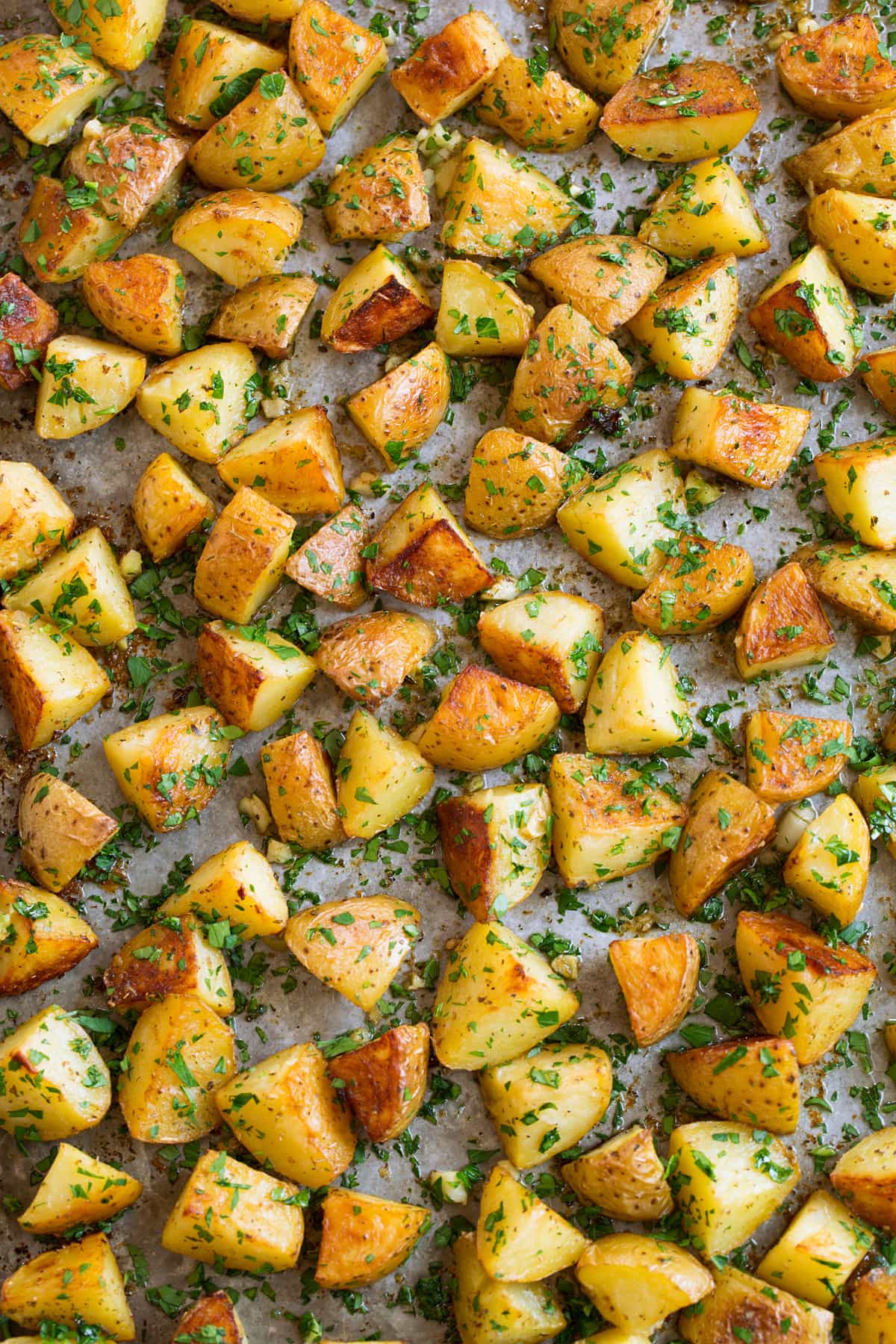 Overhead image of lemon potatoes on a metal sheet pan.