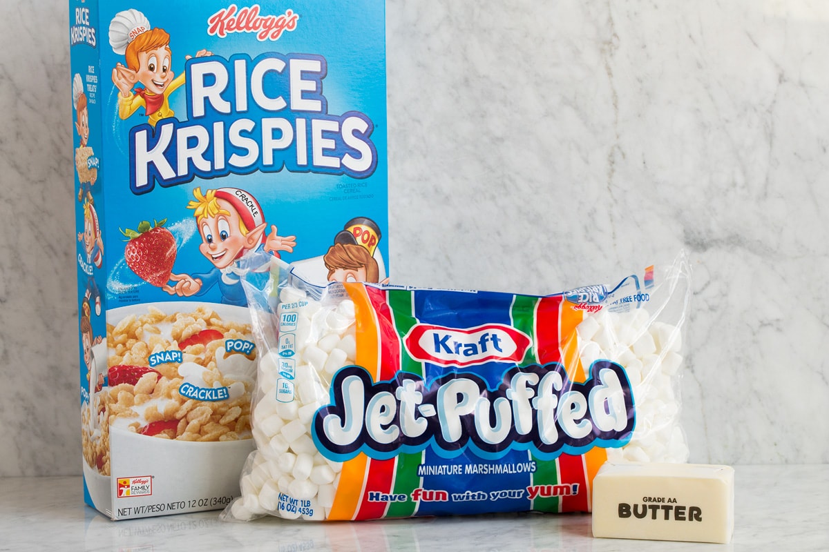 Image of three ingredients needed to make rice krispie treats shown here. Includes rice krispies cereal, mini marshmallows and butter.