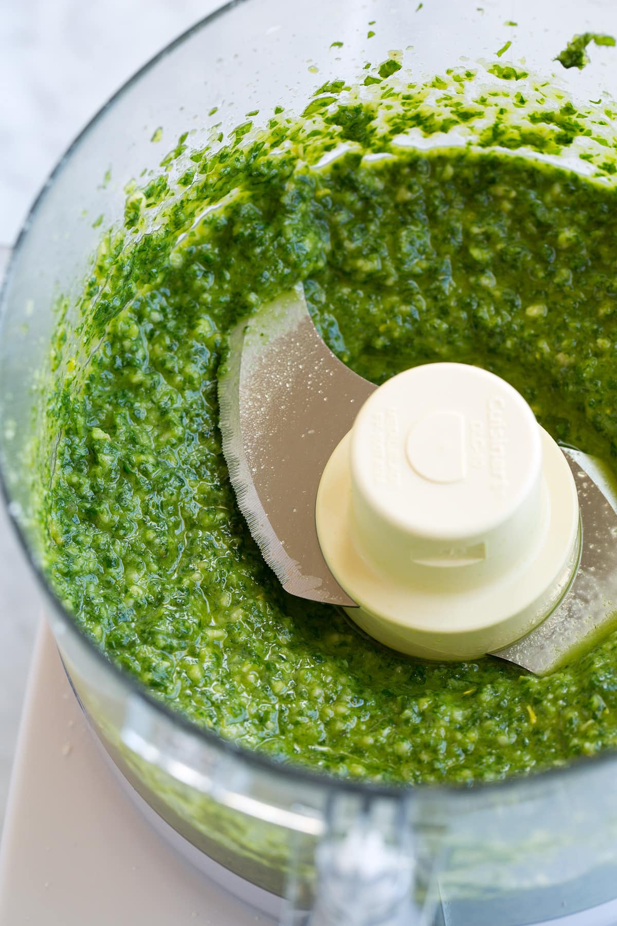 Fresh Basil Pesto Recipe Completed pesto in a food processor.