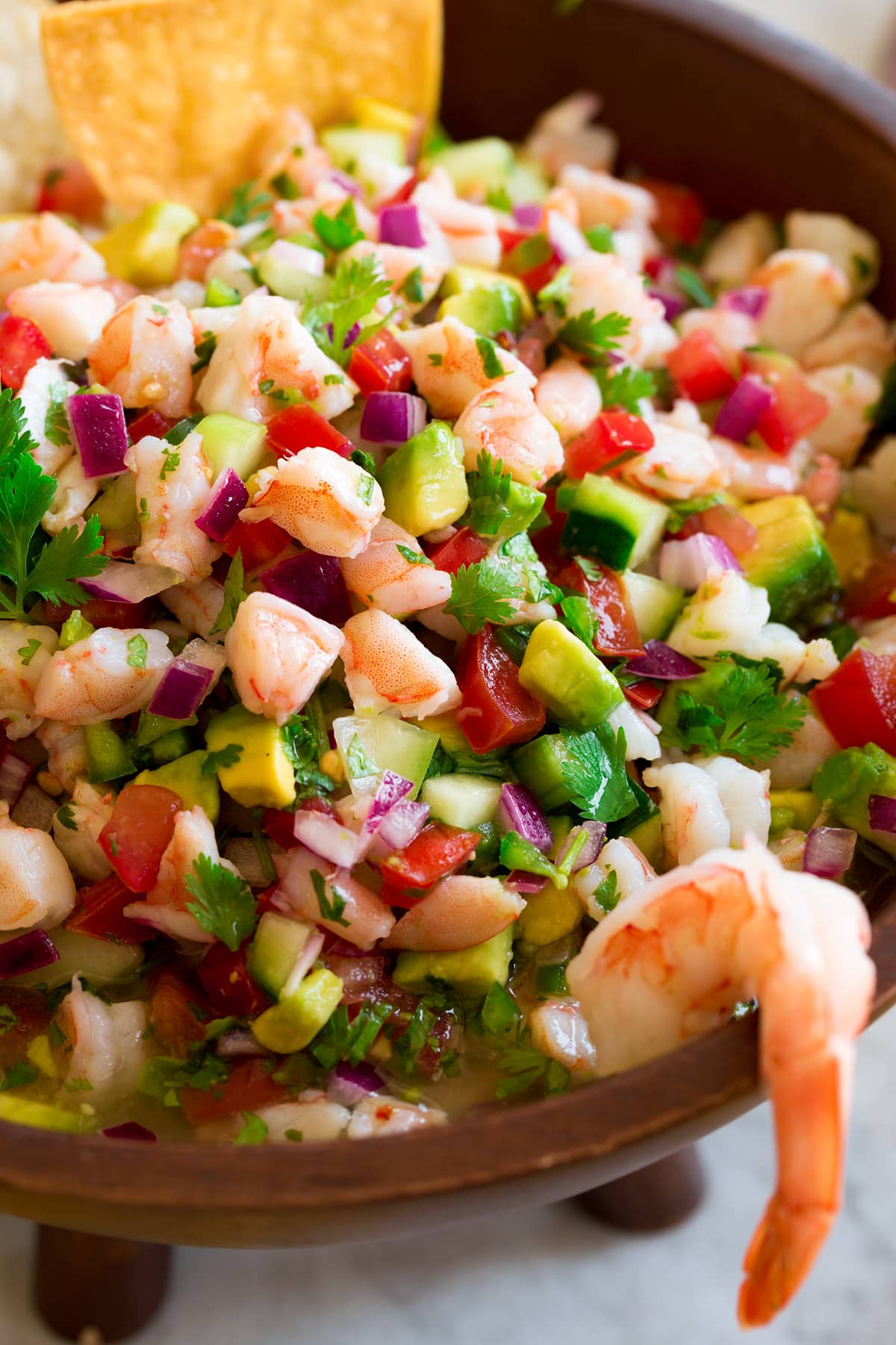 Close up image of shrimp ceviche in a wooden bowl.