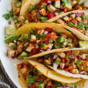 Chicken tacos on a platter shown from a side angle.