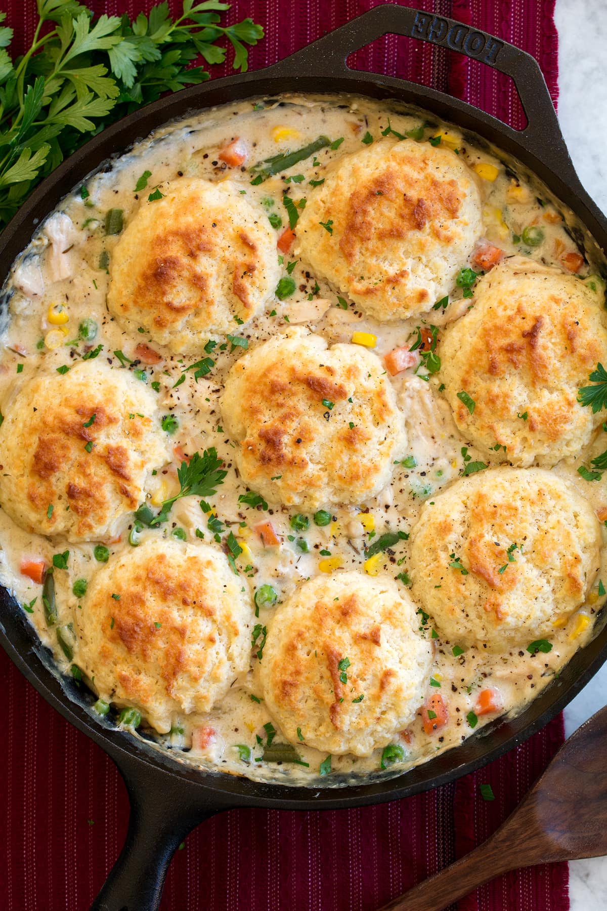 Overhead image of chicken pot pie with biscuits shown in a cast iron skillet after baking and finished.