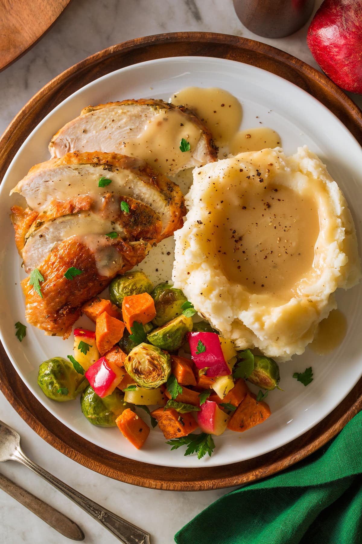 Roast Turkey Breast on a platter with a side of mashed potatoes and roasted vegetables.