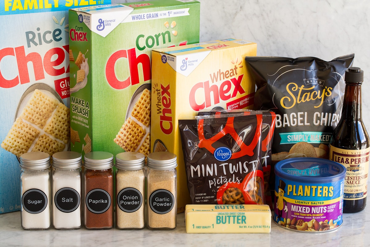 Chex Mix Image of ingredients used to make Chex Mix. Shows rice, corn and wheat Chex cereal, bagel chips, Worcestershire sauce, mixed nuts, pretzels, butter, and spices in jars.