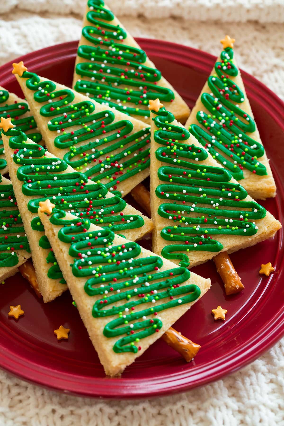 Christmas tree cookies shown on a red plate.