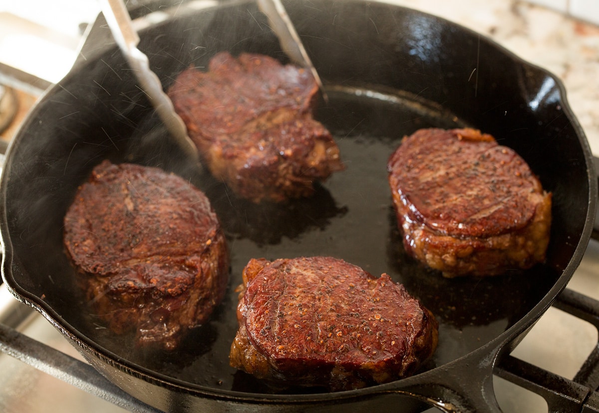 Filet Mignon Showing how to reverse sear steaks in a cast iron skillet on stovetop.