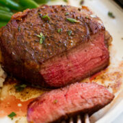 Close up image of filet mignon sliced to show medium rare interior.