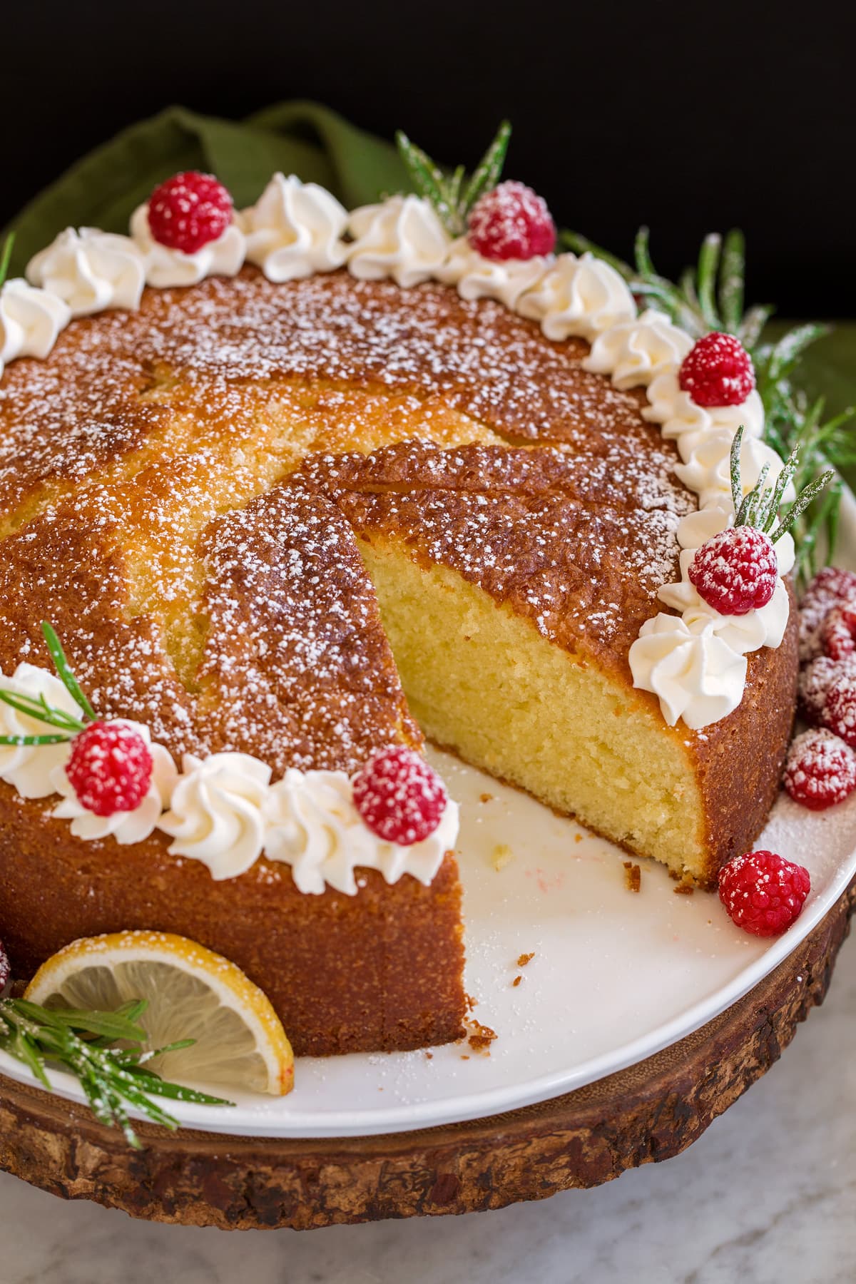 Photo of whole olive oil cake with one slice removed.