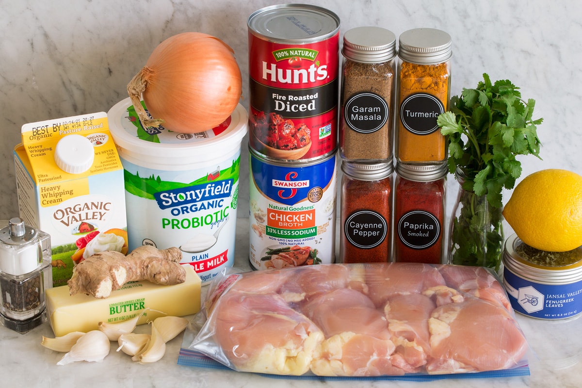 Photo of ingredients used to make butter chicken. Includes chicken thighs, cream, butter, ginger, garlic, salt and pepper, chicken broth, tomatoes, garam masala, turmeric, smoked paprika, cayenne pepper, cilantro, lemon and fenugreek.