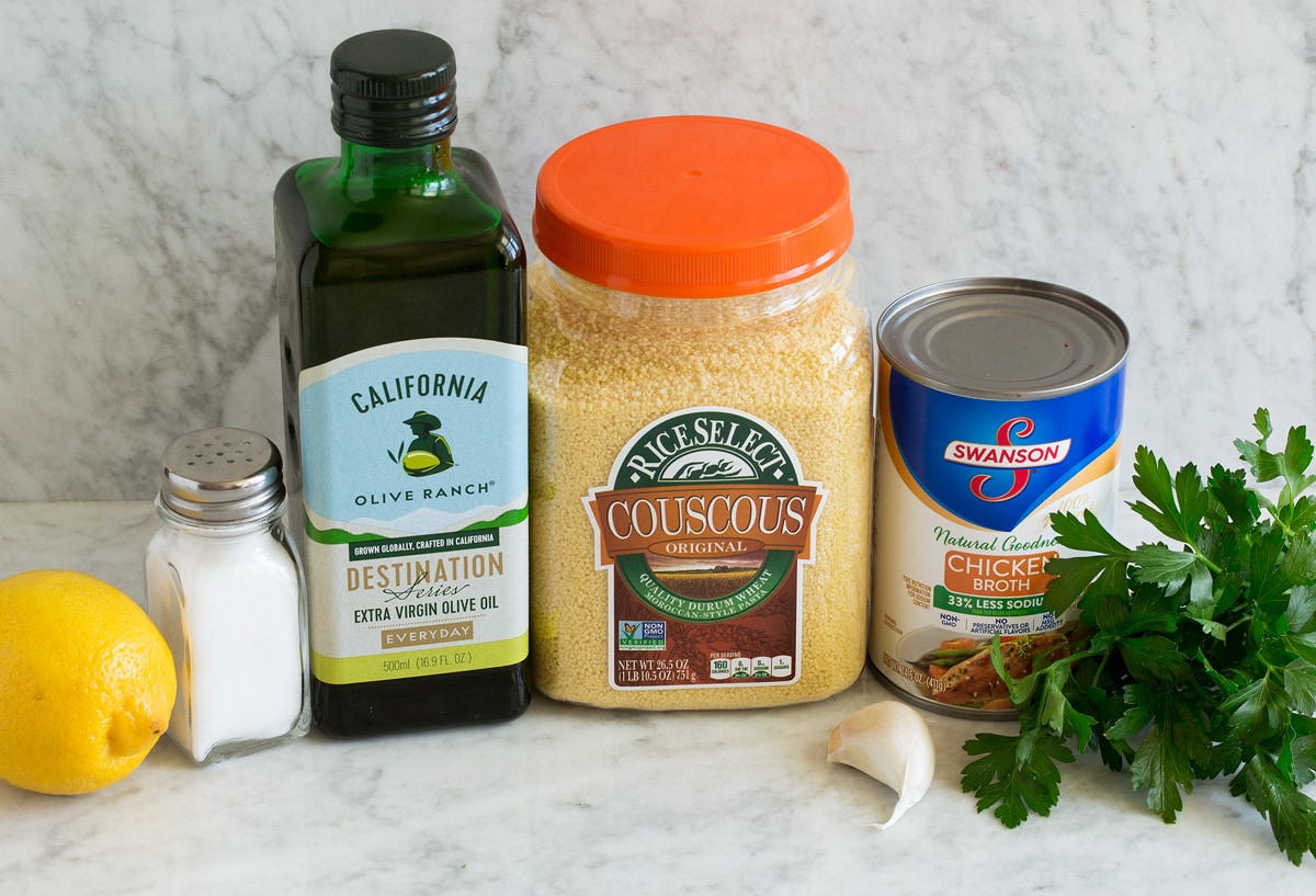 Photo of ingredients used in lemon couscous. Includes moroccan couscous, olive oil, garlic, parsley, chicken broth, lemon, salt.