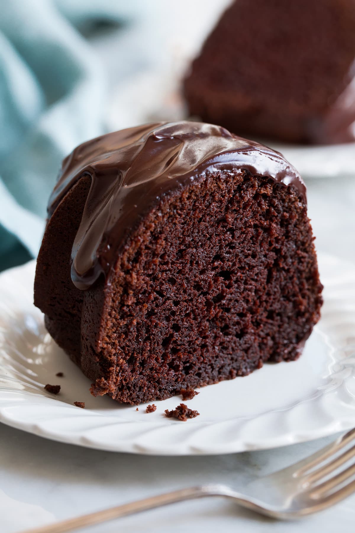 Slice of chocolate bundt cake covered with chocolate ganache.