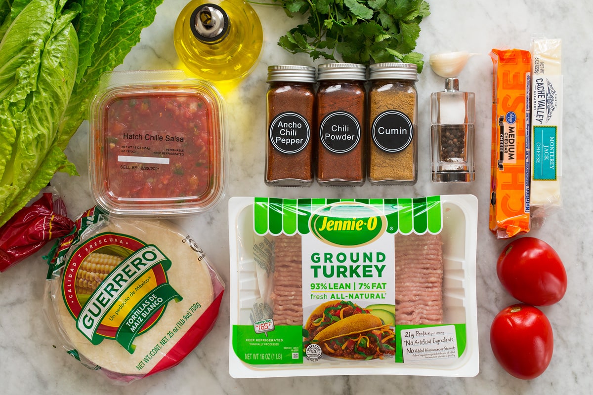 Photo: Ingredients for turkey tacos. Includes ground turkey, corn tortillas, salsa, chili powders, cumin, salt, pepper, garlic, cilantro, tomatoes, cheese, lettuce and olive oil.