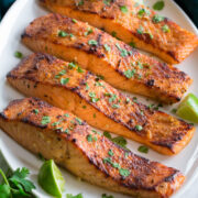 Broiled Salmon shown on a serving platter in a row of four.