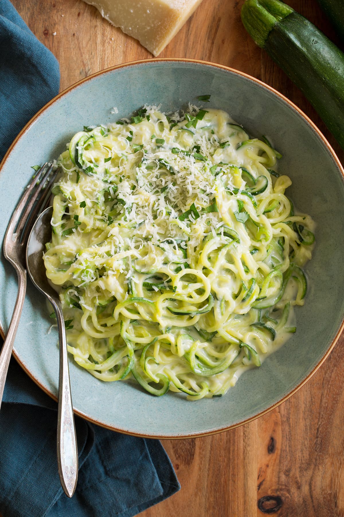 Zucchini Noodles - Zoodles Zoodles tossed with alfredo sauce, shown served in a blue pasta bowl.