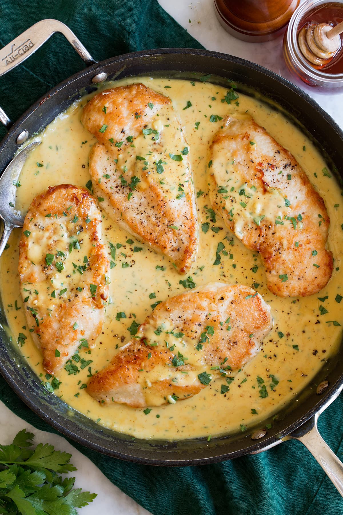 Creamy Honey Mustard Chicken Four chicken breasts in honey mustard sauce in a large black skillet.