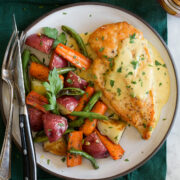 Honey mustard chicken shown with a serving suggestion of roasted vegetables on a serving plate.