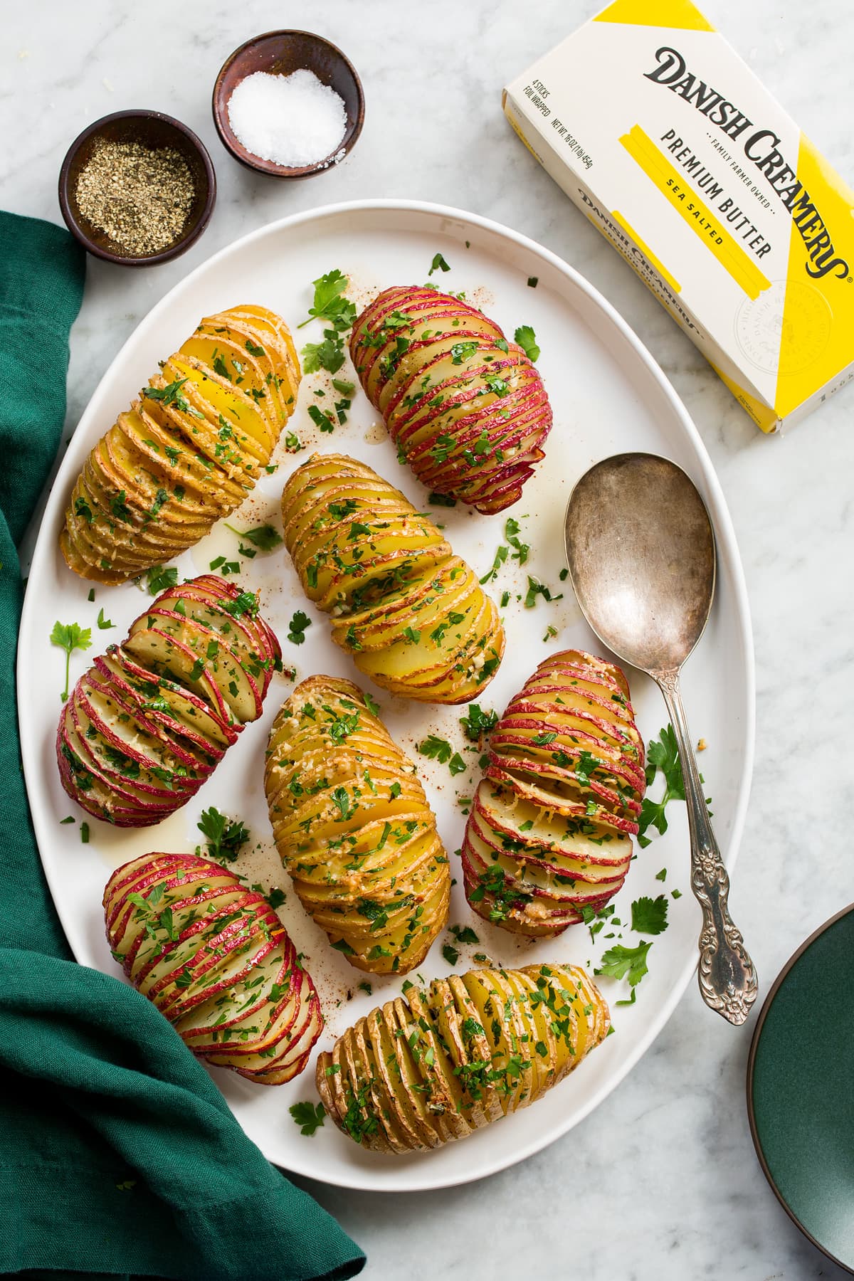 Hasselback Potatoes Overhead photo of hasselback potatoes on a white oval platter.
