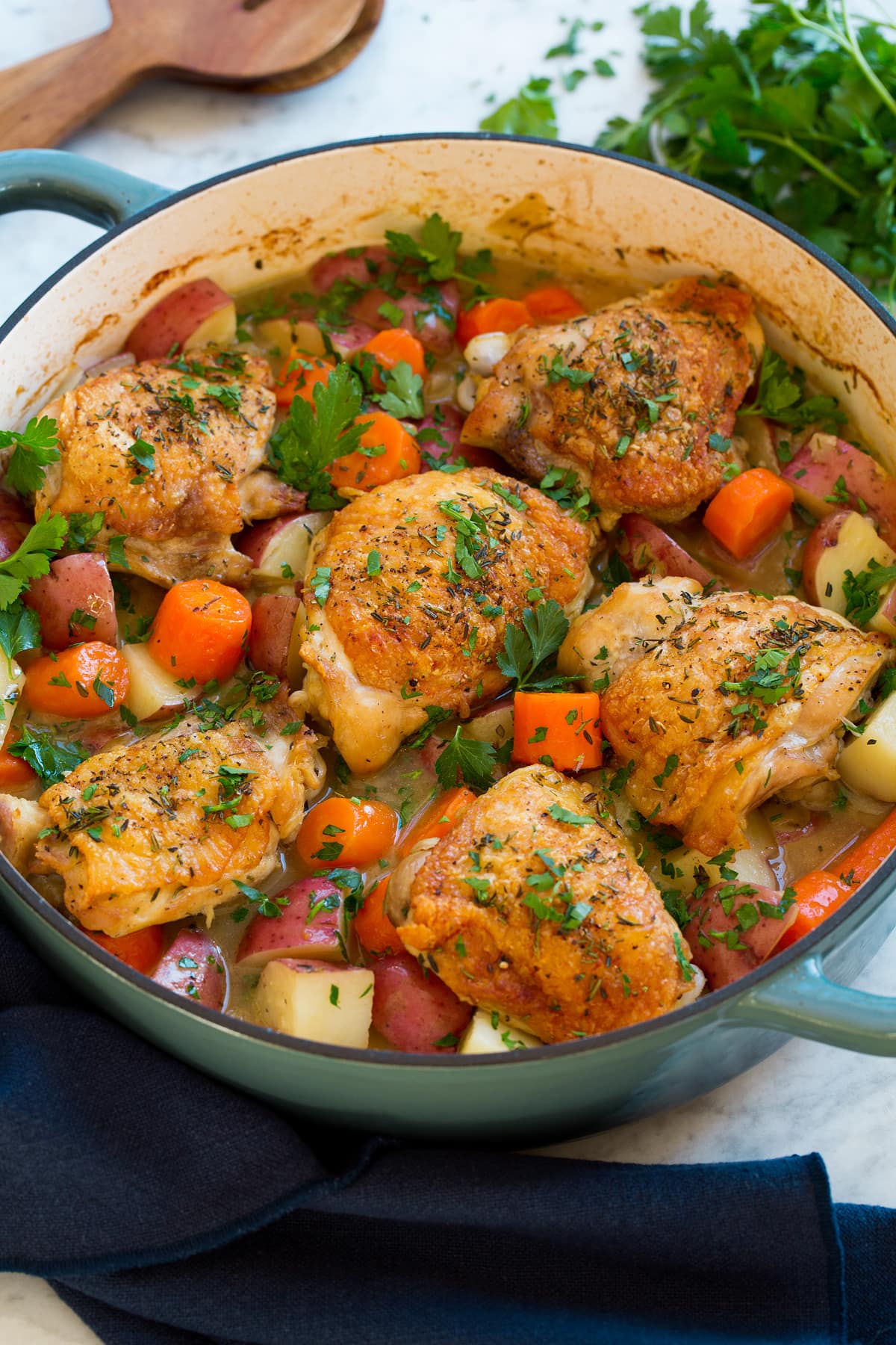 Braised chicken thighs in a pot with vegetables.