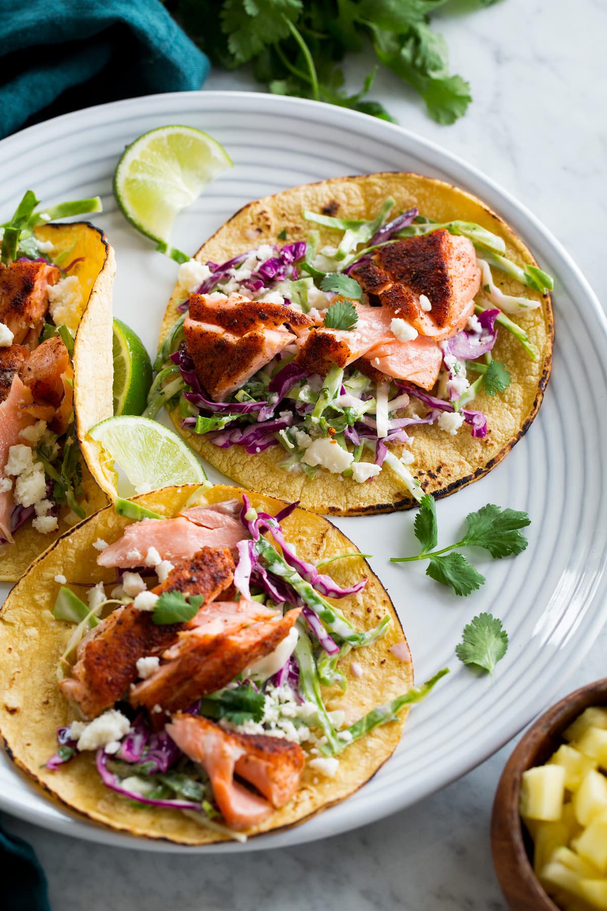 Salmon Tacos Salmon tacos on a serving plate with cilantro and limes.