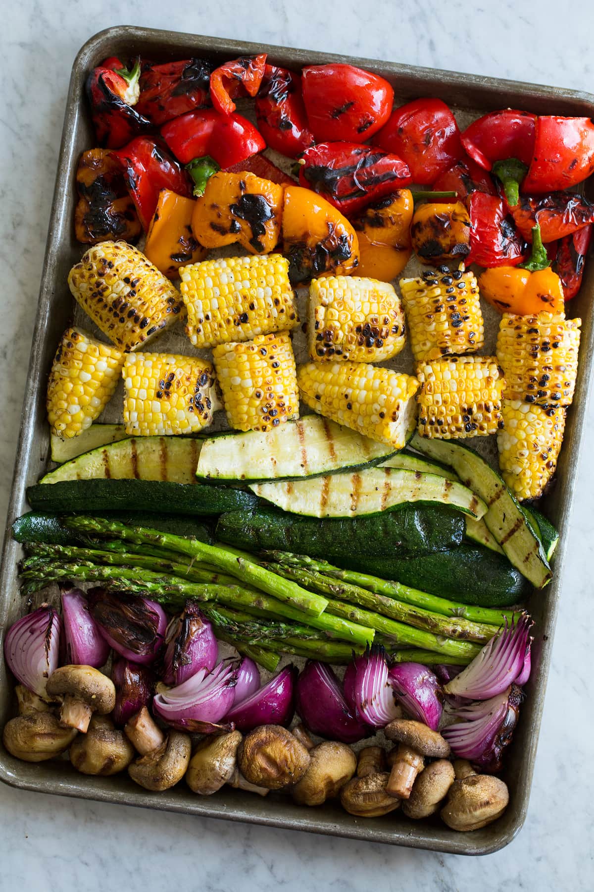 Grilled Vegetabes Grilled vegetables on a baking sheet on a marble surface.