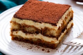 Slice of homemade tiramisu on a dessert plate.