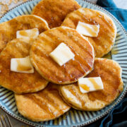 Pancakes shown at a side angle on a large blue plate.