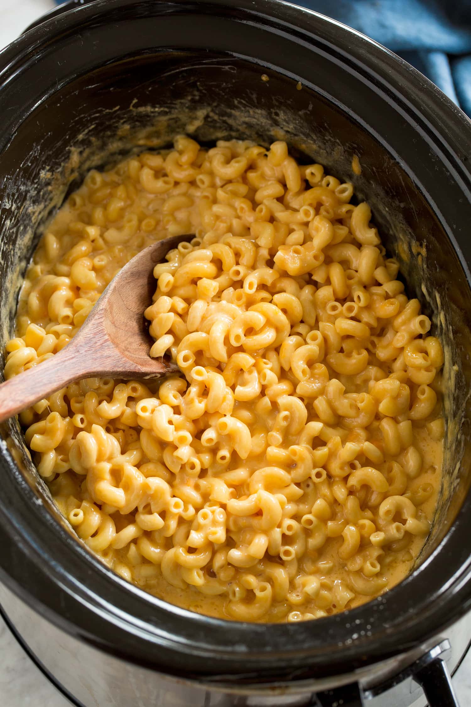 Crockpot Mac and Cheese Crockpot Mac and Cheese in a slow cooker with a wooden spoon.
