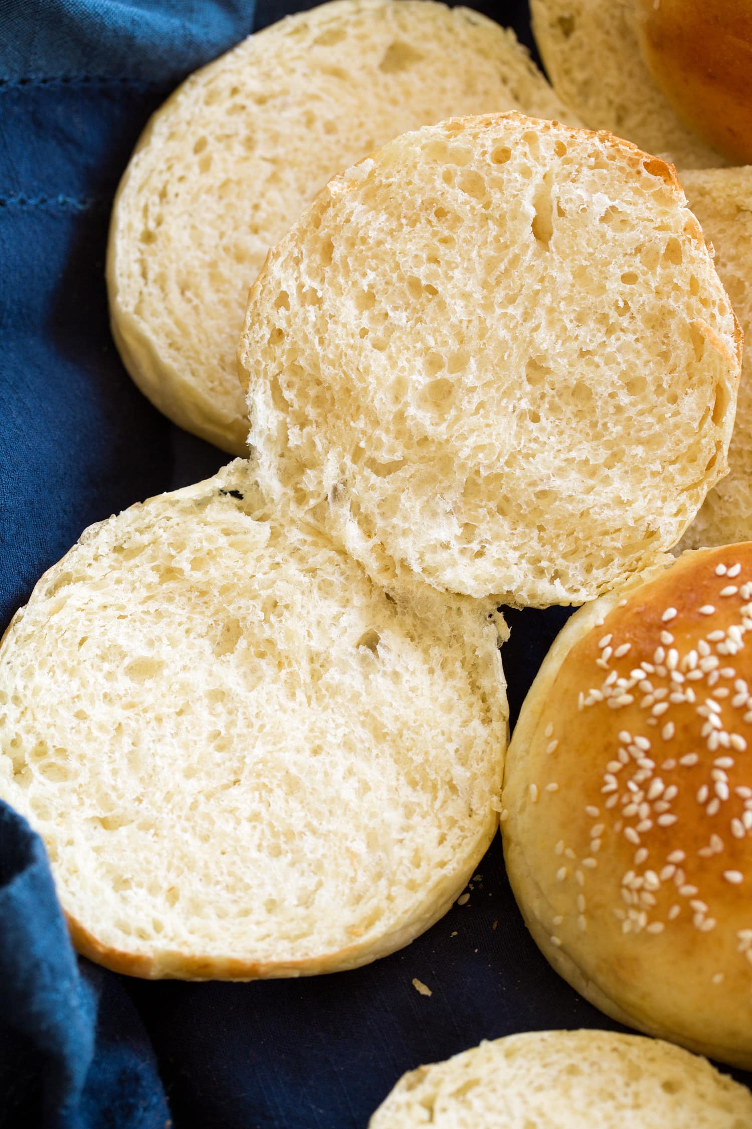 Close up photo showing texture of homemade hamburger bun sliced in half with soft airy crumb.