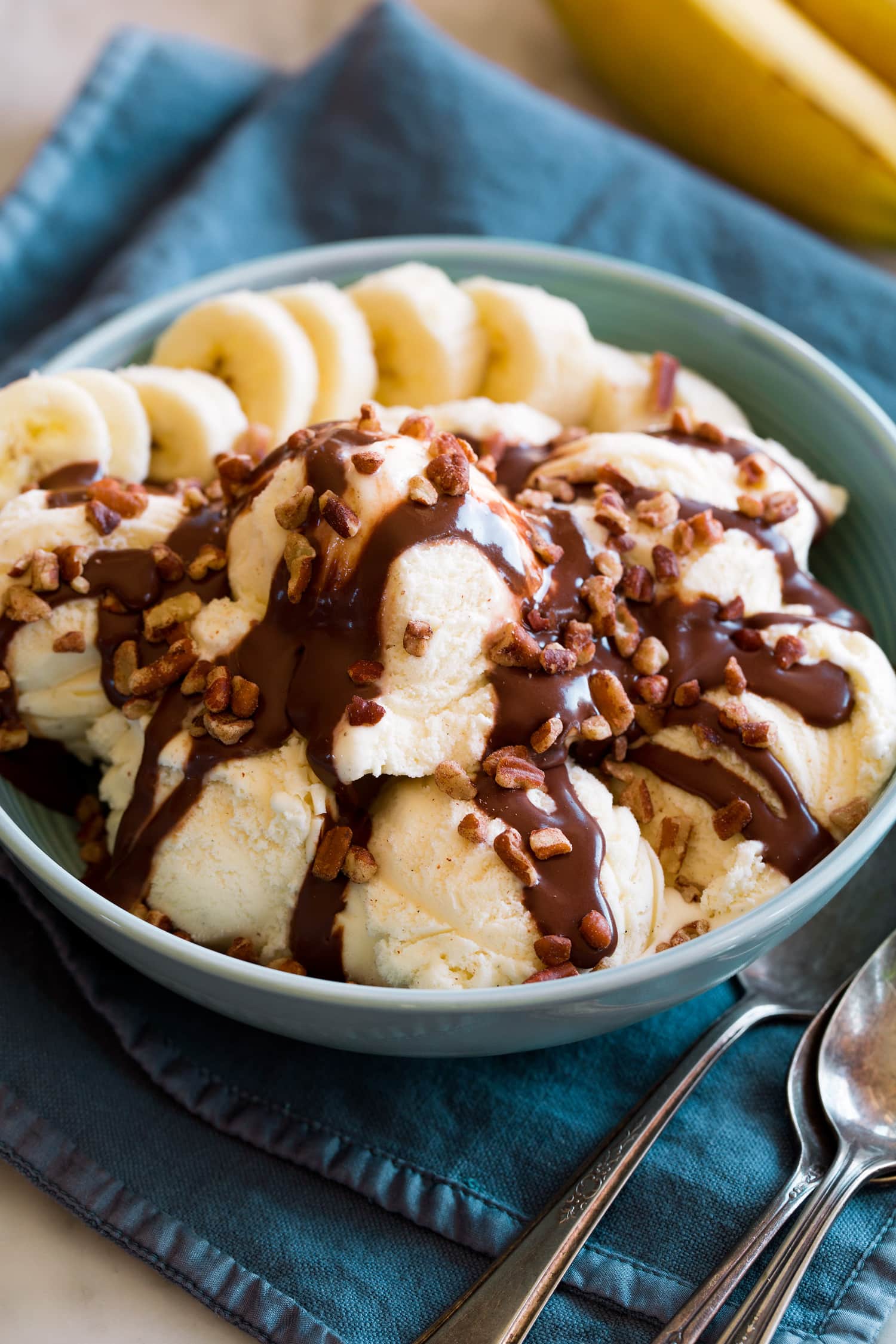 Hot Fudge Sauce Hot fudge sauce drizzled over vanilla ice cream with banana slices and chopped pecans.