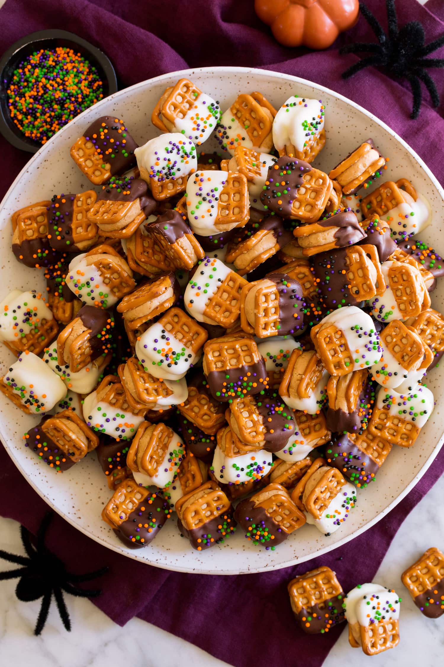 Chocolate Covered Peanut Butter Pretzel Bites covered with white chocolate and dark chocolate and sprinkles.