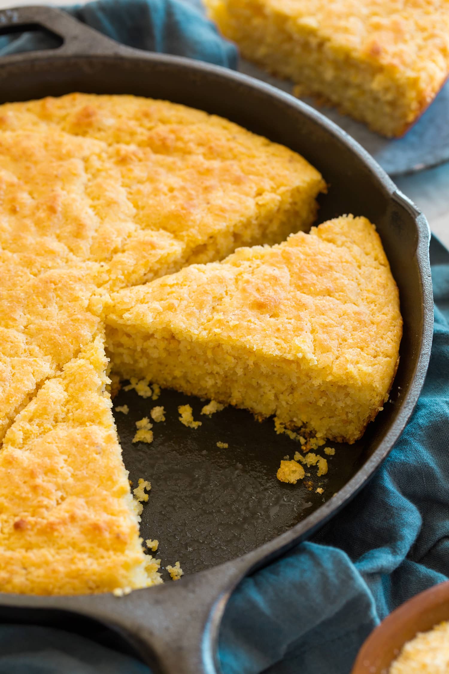 Cornbread sliced in a cast iron skilelt.