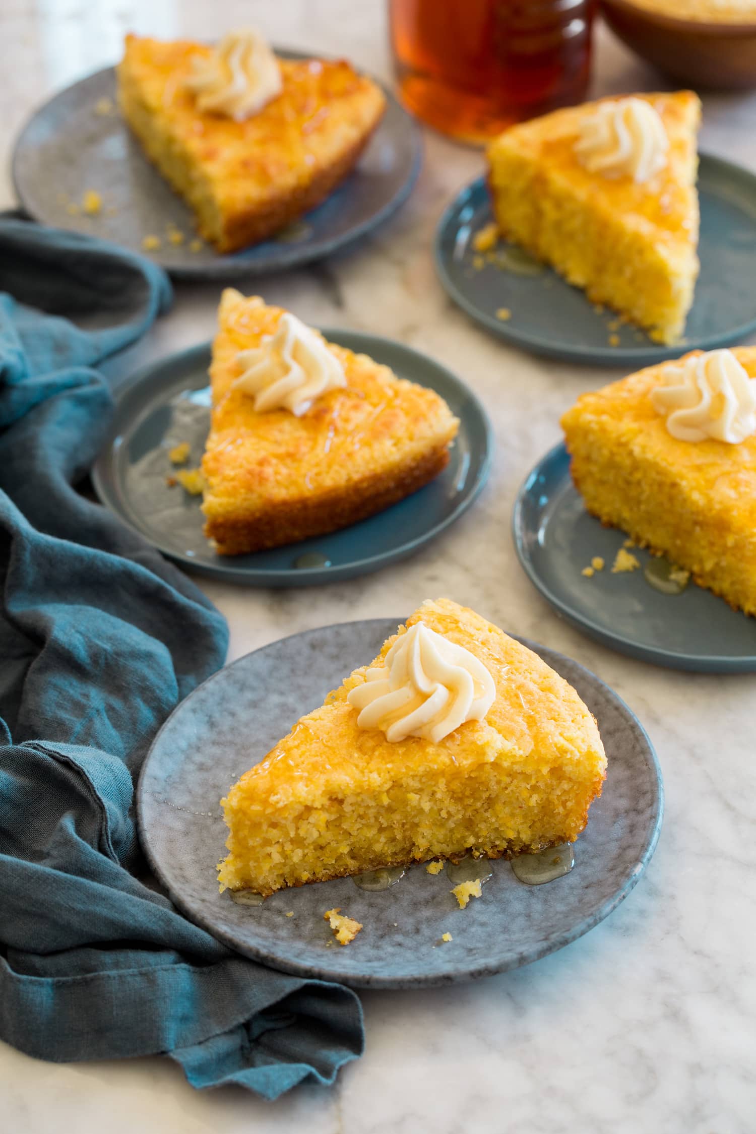 Five slices of skillet cornbread with honey and butter.
