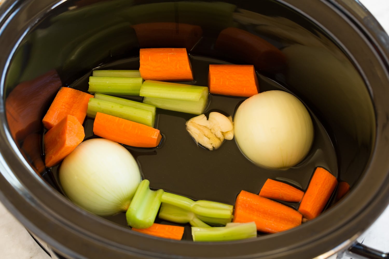 Crockpot Turkey Breast Fresh vegetables for turkey gravy in slow cooker.