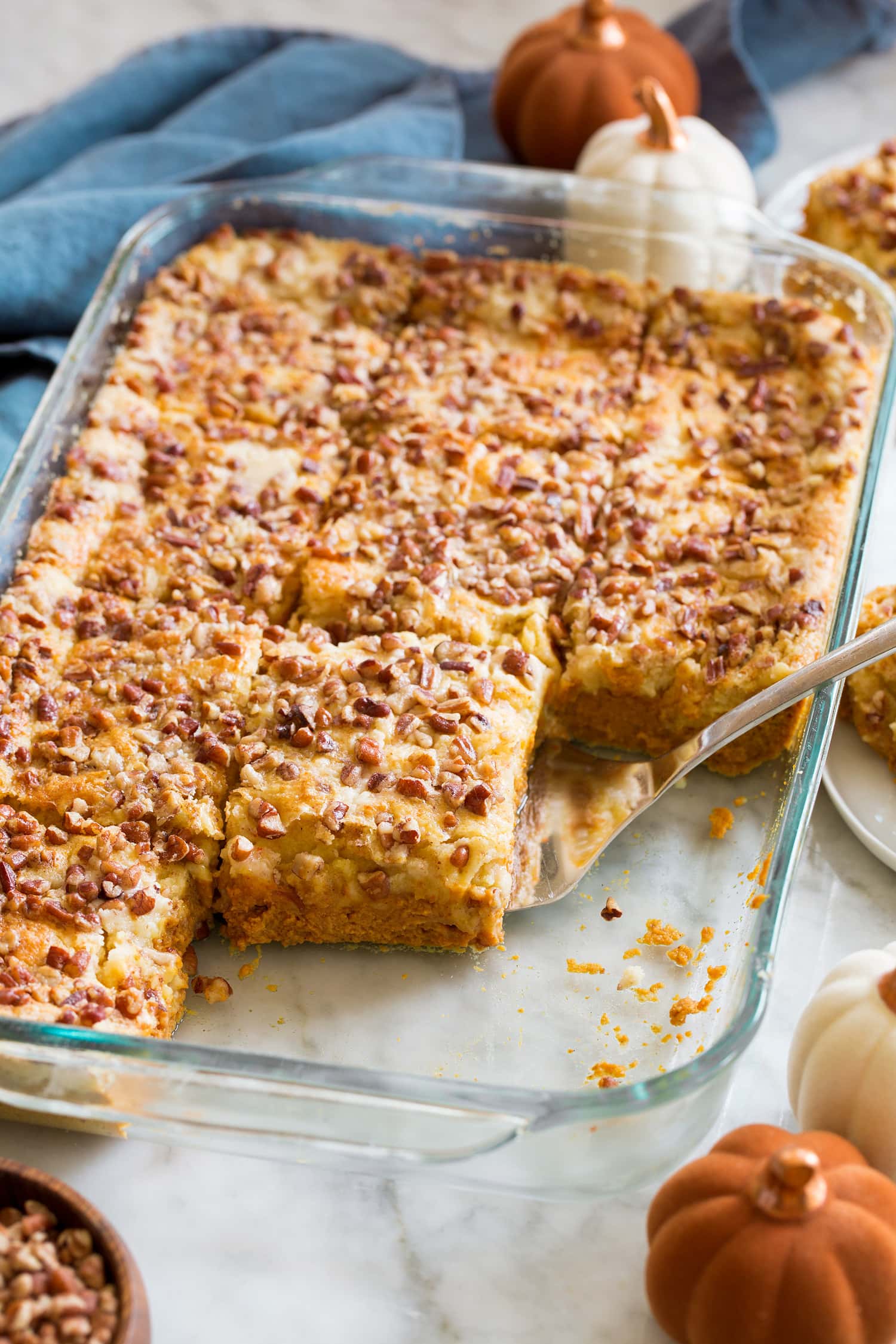 Sliced pumpkin dump cake in glass baking dish.