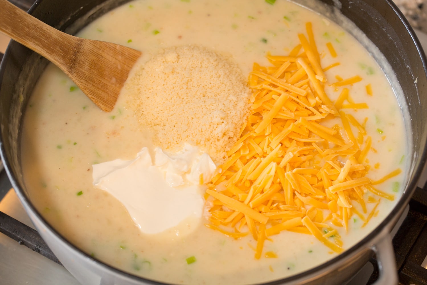 Baked Potato Soup Adding cheeses and sour cream to soup.