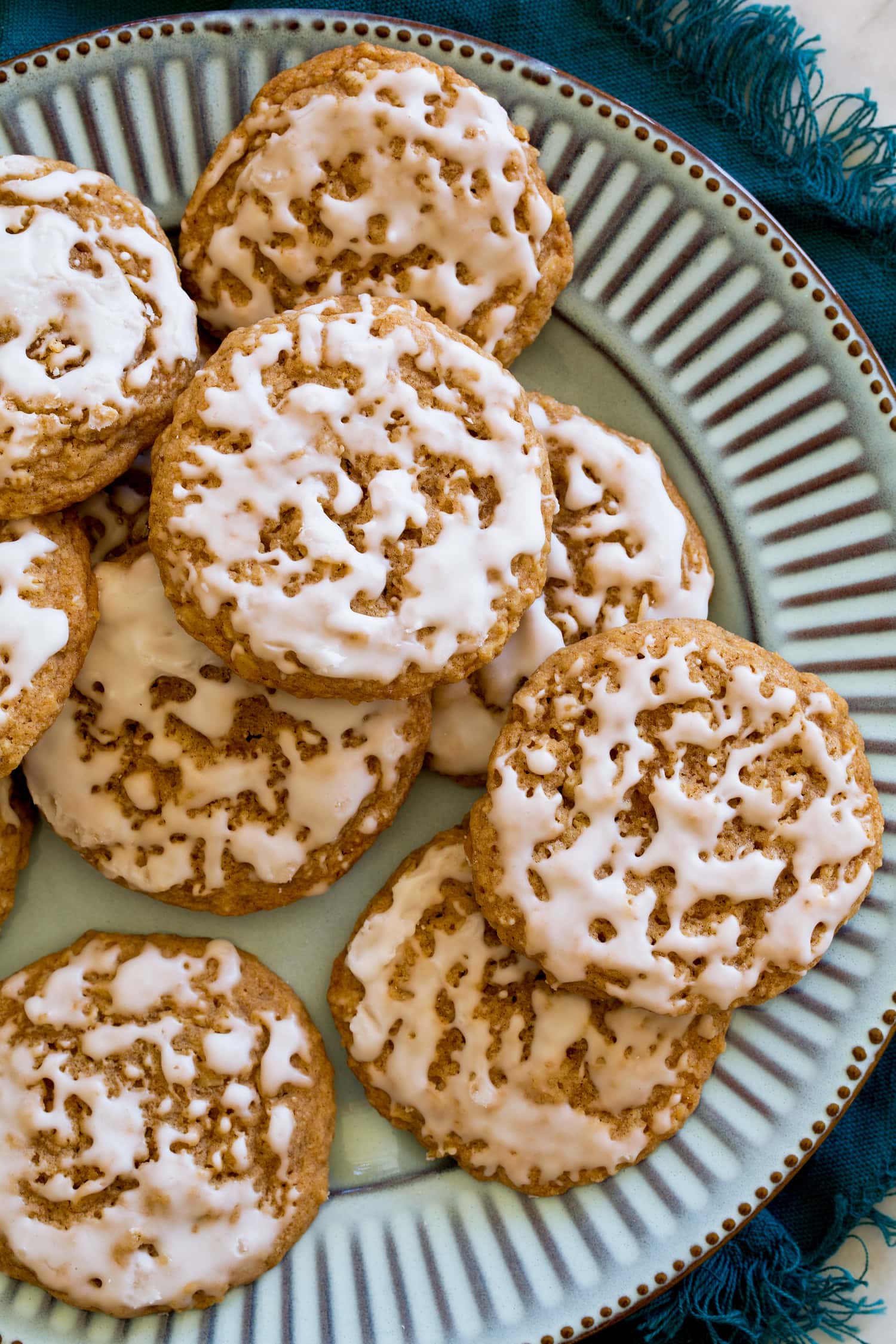 Oatmeal cookies with vanilla icing on a turquoise plate.