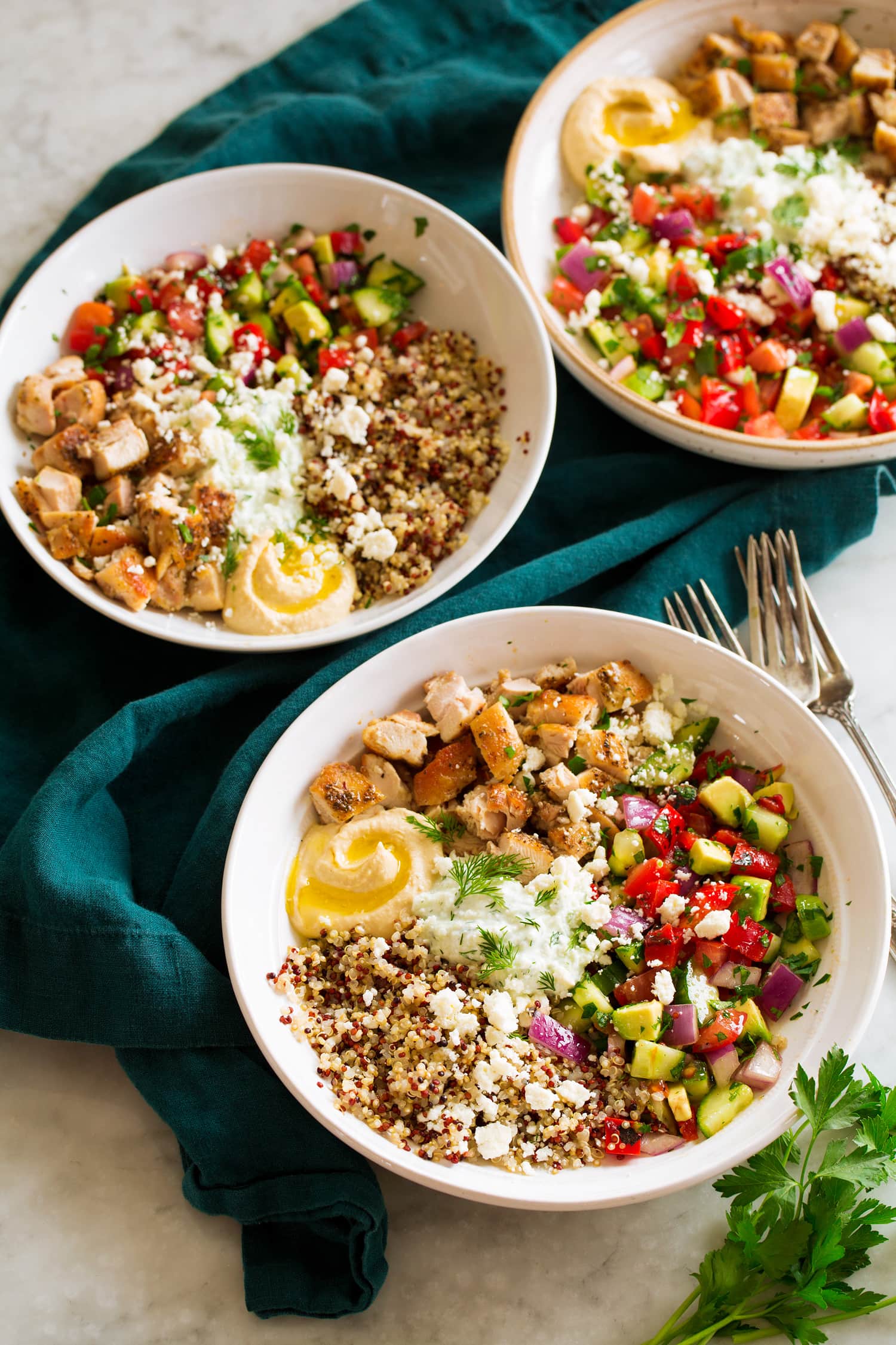 Greek Bowls Three greek chicken bowls with grains and veggies.