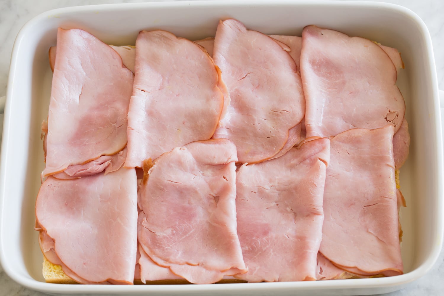 Ham and Cheese Sliders Layering ham over sliders.