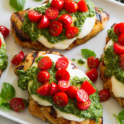 Grilled chicken margherita made with grilled chicken breasts, homemade pesto, fresh mozzarella and grape tomatoes.